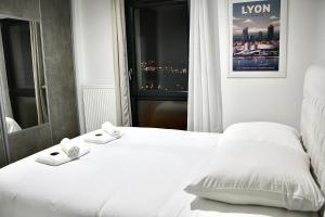 a hotel room with a white bed and a window at Villa avec vue - terrasse - parking in Irigny