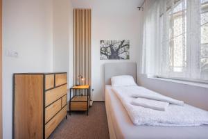 a bedroom with two beds and a dresser and a window at Penzion U Leopolda in Brno