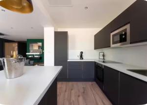 a kitchen with white counter tops and black cabinets at Loveroom Lens in Lens