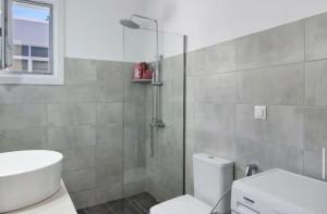 a bathroom with a shower and a toilet and a sink at Sunset Realty in Ano Syros +12 photos