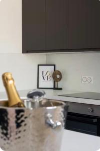 a kitchen counter with a sink with a bottle of champagne at Loveroom Lens in Lens +6 photos
