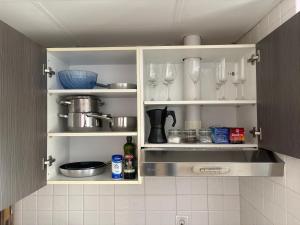 a kitchen cabinet with wine glasses and utensils at Encantador, tranquilo y centrico in Málaga