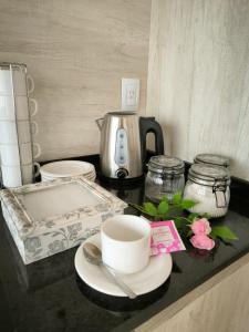 a counter top with a coffee pot and cups and plates at Departamento en Reconquista in Reconquista