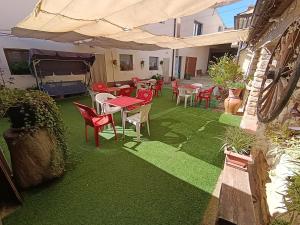 a patio with red tables and chairs on green grass at Habitación independiente II en Casa Rural Javier in Valmuel