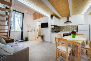 a kitchen and a living room with a table and a couch at Respiro di Chiaia in Procida +6 photos