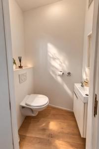 a white bathroom with a toilet and a sink at The White Boutique Loft in Antwerp +6 photos