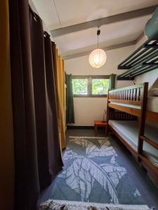 a bedroom with a bunk bed and a rug at Maison avec bungalow Ylang in Uturoa
