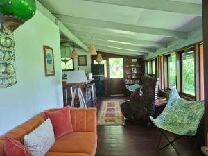 a living room with a couch and chairs at Maison avec bungalow Ylang in Uturoa