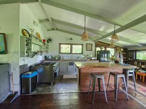 a large kitchen with a large wooden island in the middle at Maison avec bungalow Ylang in Uturoa