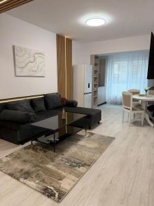 a living room with a black couch and a table at The Urban Hide by D'or Selection in Bucharest
