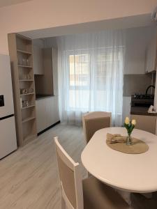 a kitchen and dining room with a white table and chairs at The Urban Hide by D'or Selection in Bucharest