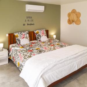 a bedroom with a bed with a floral comforter at Gîte Chez Claudia in Marsolan