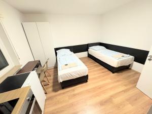a small room with two beds and a desk at Studio Apartment next to Airport in Kelsterbach