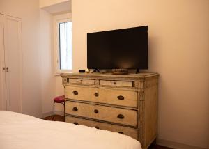a dresser with a flat screen tv on top of it at Luxury Apartment in Moltrasio Center in Moltrasio