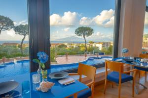 a dining room with a view of a pool at Hilton Sorrento Palace in Sorrento