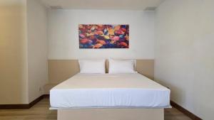 a bed in a room with a painting on the wall at ABC-53 Housing in Medellín
