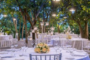 a table set up for a wedding with white tables and chairs at Hilton Sorrento Palace in Sorrento +228 photos