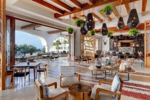 a lobby of a restaurant with tables and chairs at Hilton Los Cabos in San José del Cabo