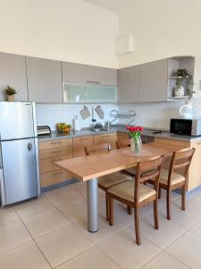 a kitchen with a wooden table and a refrigerator at Petrovac Pearl Apartment in Petrovac na Moru