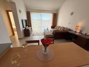 a living room with a vase of flowers on a table at Petrovac Pearl Apartment in Petrovac na Moru
