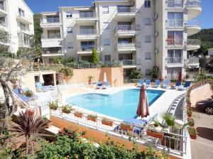 an apartment with a swimming pool in front of a building at Petrovac Pearl Apartment in Petrovac na Moru