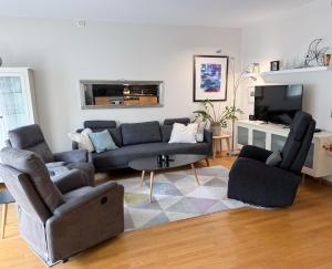 a living room with a couch and two chairs at The Seabreeze Marina in Mandal
