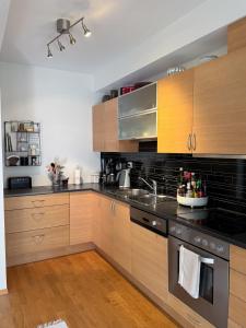 a kitchen with wooden cabinets and black appliances at The Seabreeze Marina in Mandal