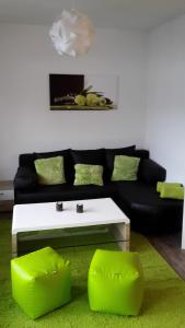 ein Wohnzimmer mit einem schwarzen Sofa und einem weißen Couchtisch in der Unterkunft Ferienwohnung "kleines glück" in Winterberg-Niedersfeld in Winterberg