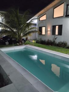 a swimming pool in front of a house at night at Casa Telhado Inclinado in Saquarema