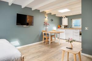 a bedroom with a bed and a kitchen with a table at Studio Luxe 31 Zandvoort met gratis parkeerplaats in Zandvoort