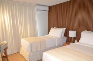 a hotel room with two beds and a window at Hotel Raices del Arapey in Termas del Arapey +21 photos