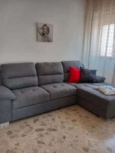 a gray couch with two red pillows in a living room at Casa vacanza dai Nonni Ntoni in Acquarica del Capo
