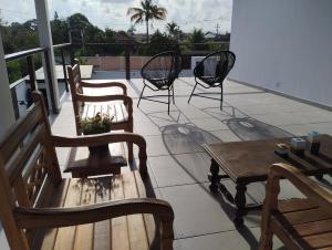 a patio with chairs and a table on a balcony at Casa Telhado Inclinado in Saquarema