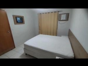 a small bedroom with a white bed in a room at Boulevard suite hotel apartamento 434 in Caldas Novas