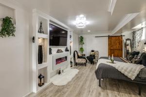 a living room with a bed and a couch and a tv at Oasis Hideaway Apt w/ Rainforest Shower! in Baltimore