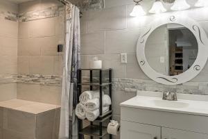 a bathroom with a sink and a mirror at Oasis Hideaway Apt w/ Rainforest Shower! in Baltimore +21 photos