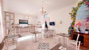 a room with tables and chairs and a painting on the wall at Olimpo degli Dei in Agerola