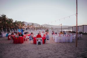 a group of people sitting at tables on the beach at Buena Vista Oceanfront & Hot Springs Resort in Buenavista