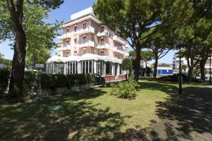 un edificio rosa con árboles delante en Hotel El Paso, en Lido di Jesolo