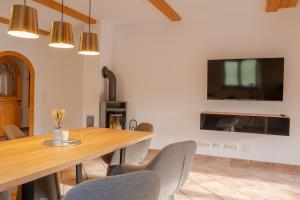 a dining room with a table and chairs and a tv at Alps Living Söll in Söll