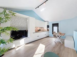a kitchen with white cabinets and a table in a room at Casa PedraParda in O Grove