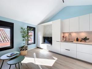 a kitchen with white cabinets and a table at Casa PedraParda in O Grove