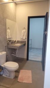 a bathroom with a toilet and a sink and a mirror at Camisão CasaJuMa Pixixi in Aquidauana