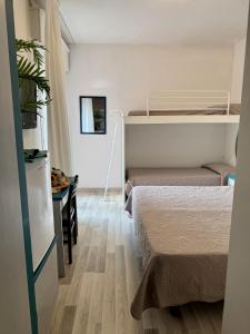 una habitación pequeña con dos camas y una mesa en Hotel El Paso, en Lido di Jesolo