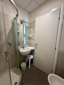 un baño con lavabo, inodoro y ducha en Hotel El Paso, en Lido di Jesolo 30 fotos más