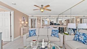 a living room with a couch and a ceiling fan at Beachfront Breeze by AvantStay in Panama City Beach