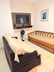 a living room with two beds and a flat screen tv at RESIDENCIAL SOPHIA in Eunápolis
