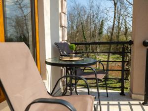 a table and chairs on a balcony with a window at Apartment Padre e hija in Ponari