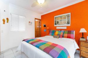 a bedroom with a bed with an orange wall at Charming & Cozy Beachfront Condo Las Olas I 19 in Puerto Peñasco