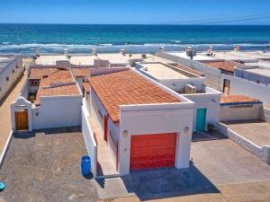 a building with a red door on the beach at Charming & Cozy Beachfront Condo Las Olas I 19 in Puerto Peñasco